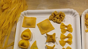 Verschiedene selbstgemachte Sorten von Teigwaren und Ravioli auf einem Papierteller. 