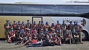 Gruppenbild einer Guggenmusik mit dem Reisecar von VBL REISEN im Hintergrund. 